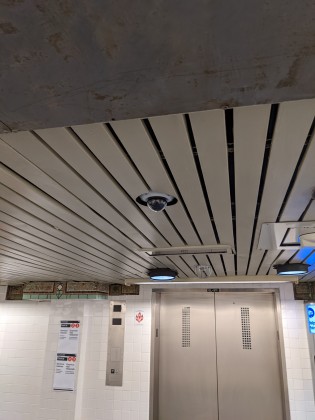 Ceiling video camera at the mezzanine level of station